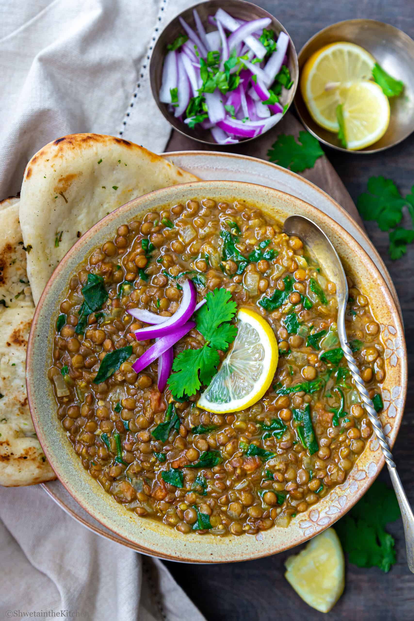 Masoor Dal Palak in a bowl with naan on side