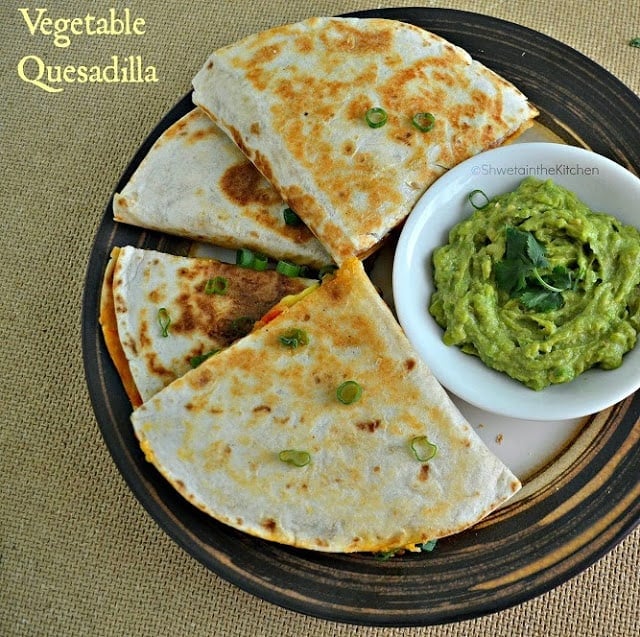 Quesadillas served on a plate with a small bowl of guacamole