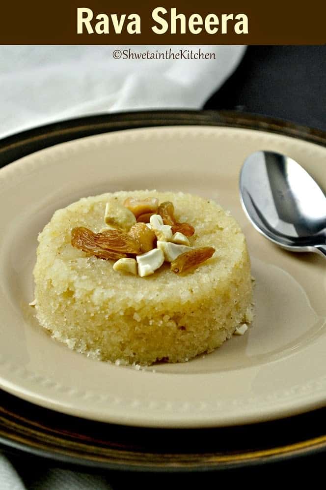 A around of rava sheera served on a plate with a spoon and topped with nuts and raisins