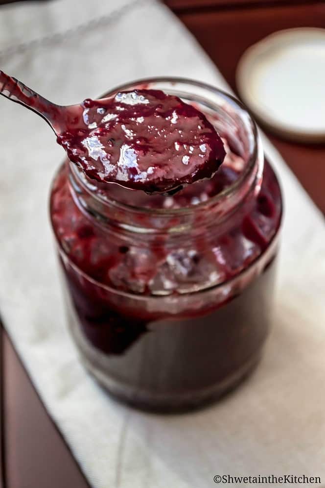 Plum chutney being spooned out of a jar