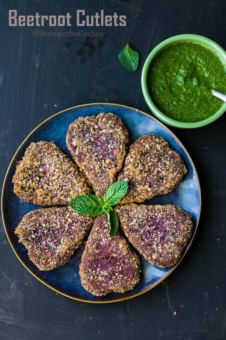Beetroot Tikki on a blue plate with green chutney on side