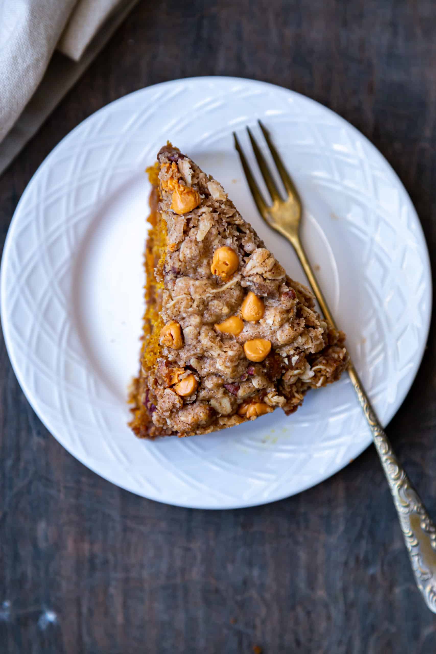 Slice of Pumpkin Streusel coffee cake on white plate with a fork