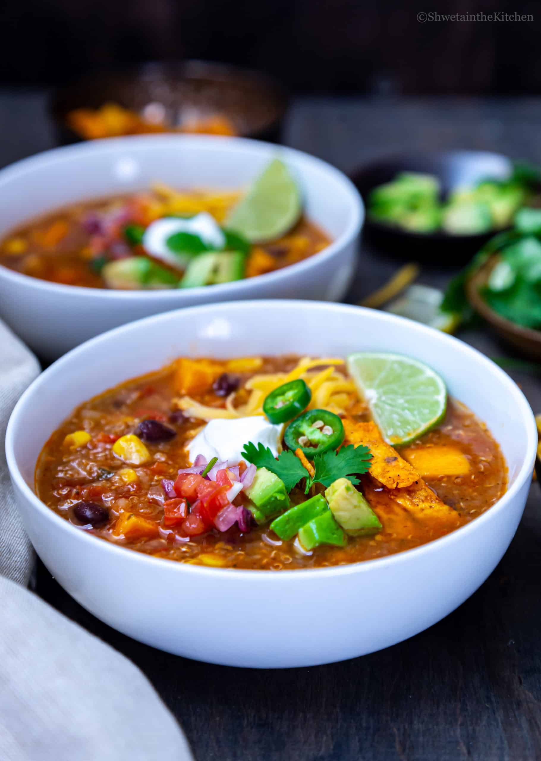 white bowl of Instant Pot Enchiladas Soup with focus on toppings in the centre. 