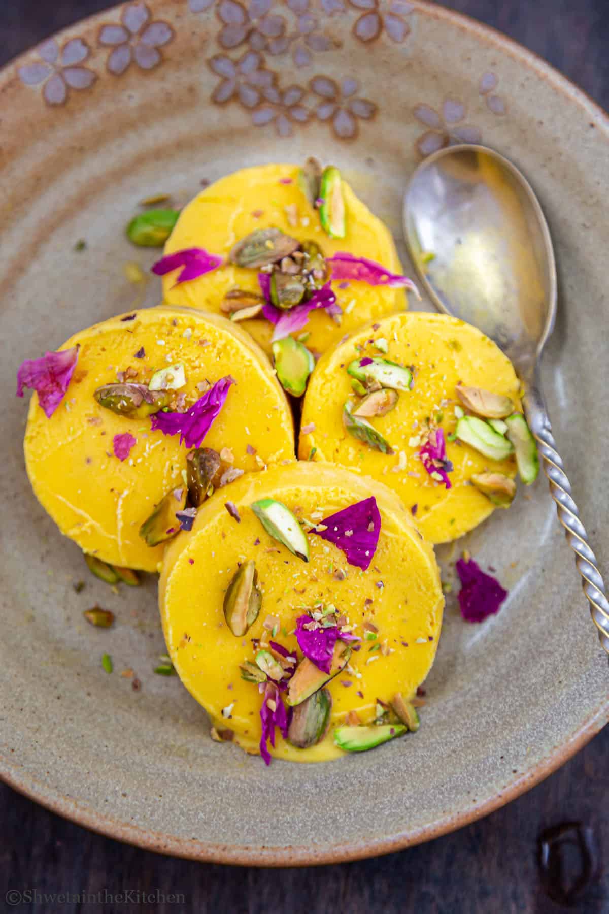 Sliced kulfi pieces of plate with spoon on side
