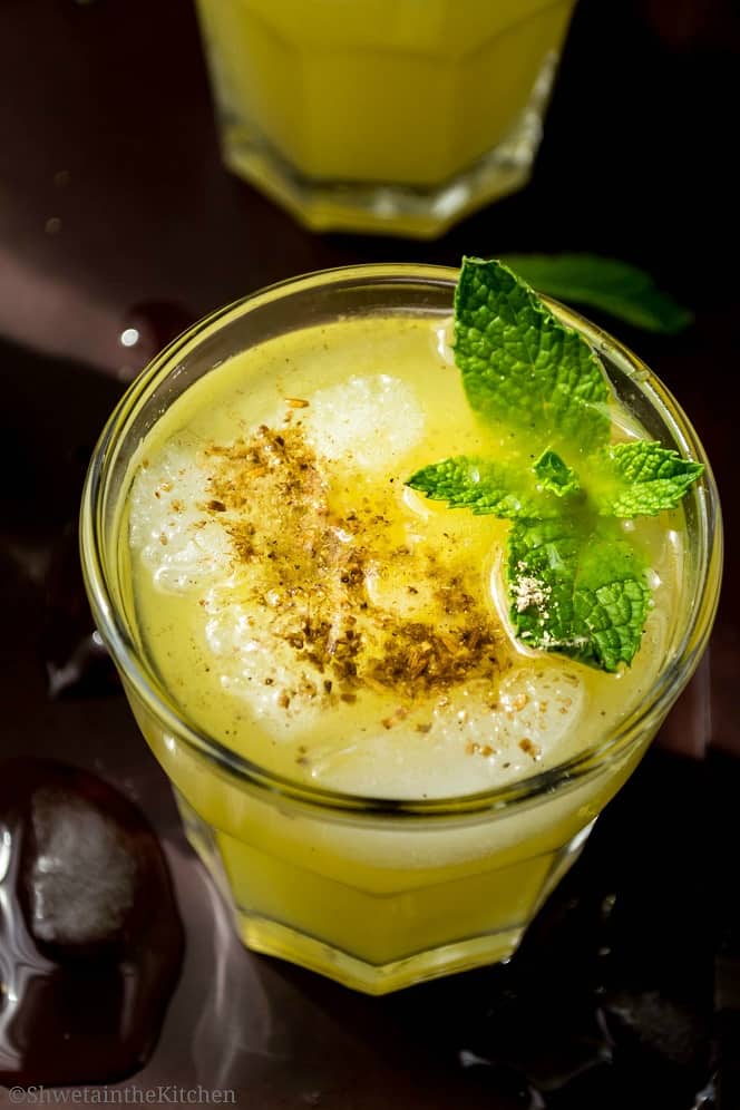 Top view of Aam panna glass garnished with mint and cumin seeds powder