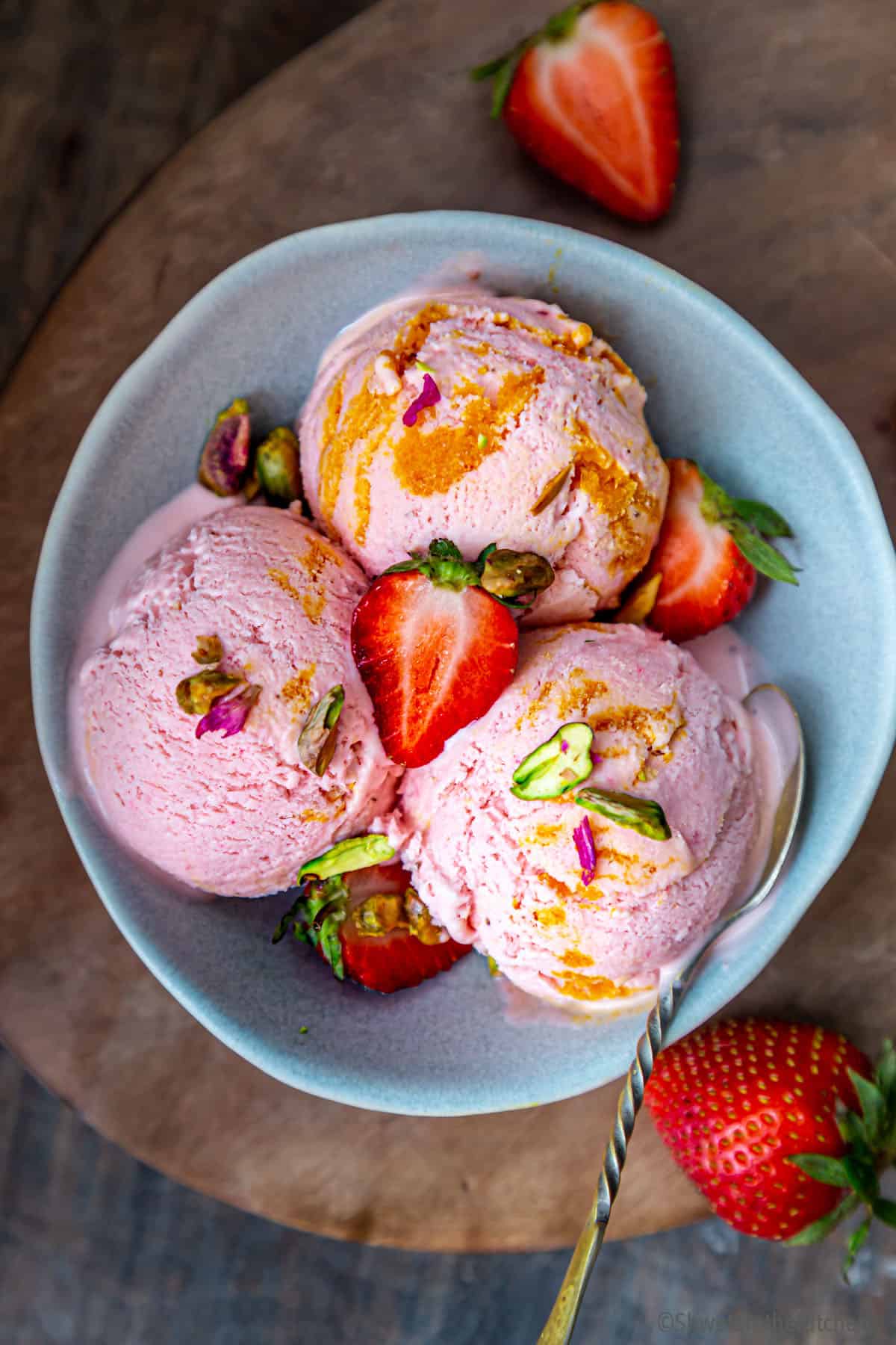 Three scoops of Strawberry Mango Swirl Icecream in blue bowl