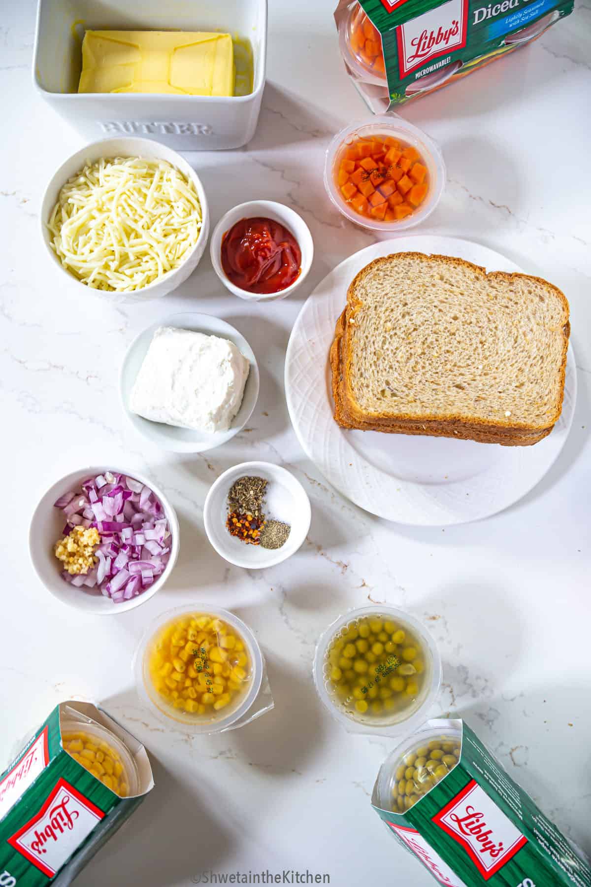 All the ingredients for vegetable sandwich laid on a white surface