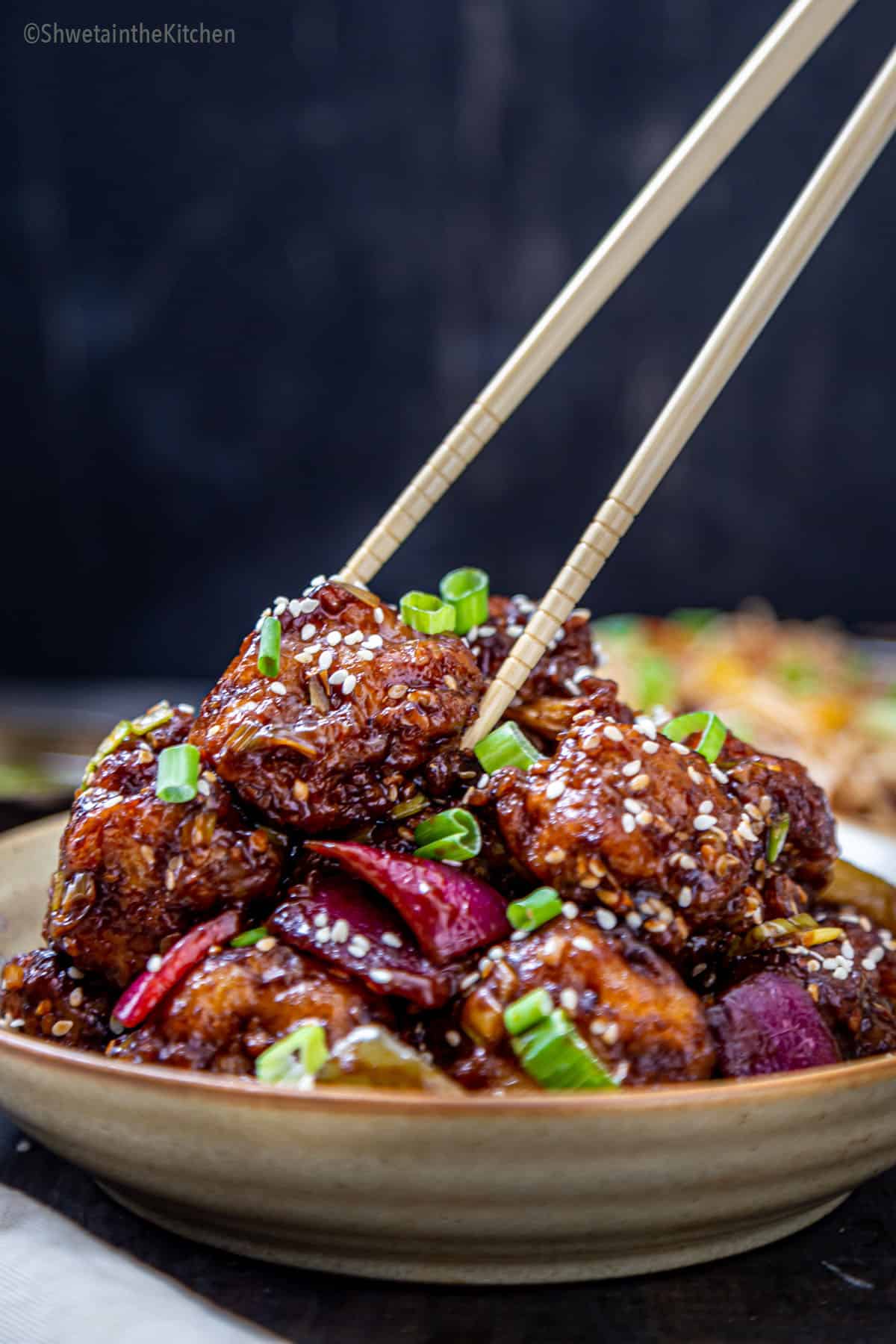Gobi Manchurian dry stacked on plate and picked by chopsticks