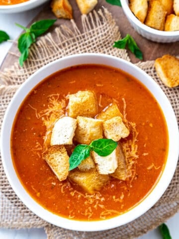 Bowl of Tomato basil soup with crouton and basil leaves