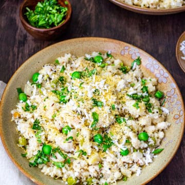 Rava upma served in a large bowl next to a small bowl of fresh cilantro.