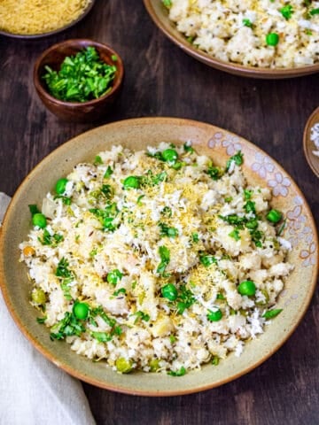 Rava upma served in a large bowl next to a small bowl of fresh cilantro.