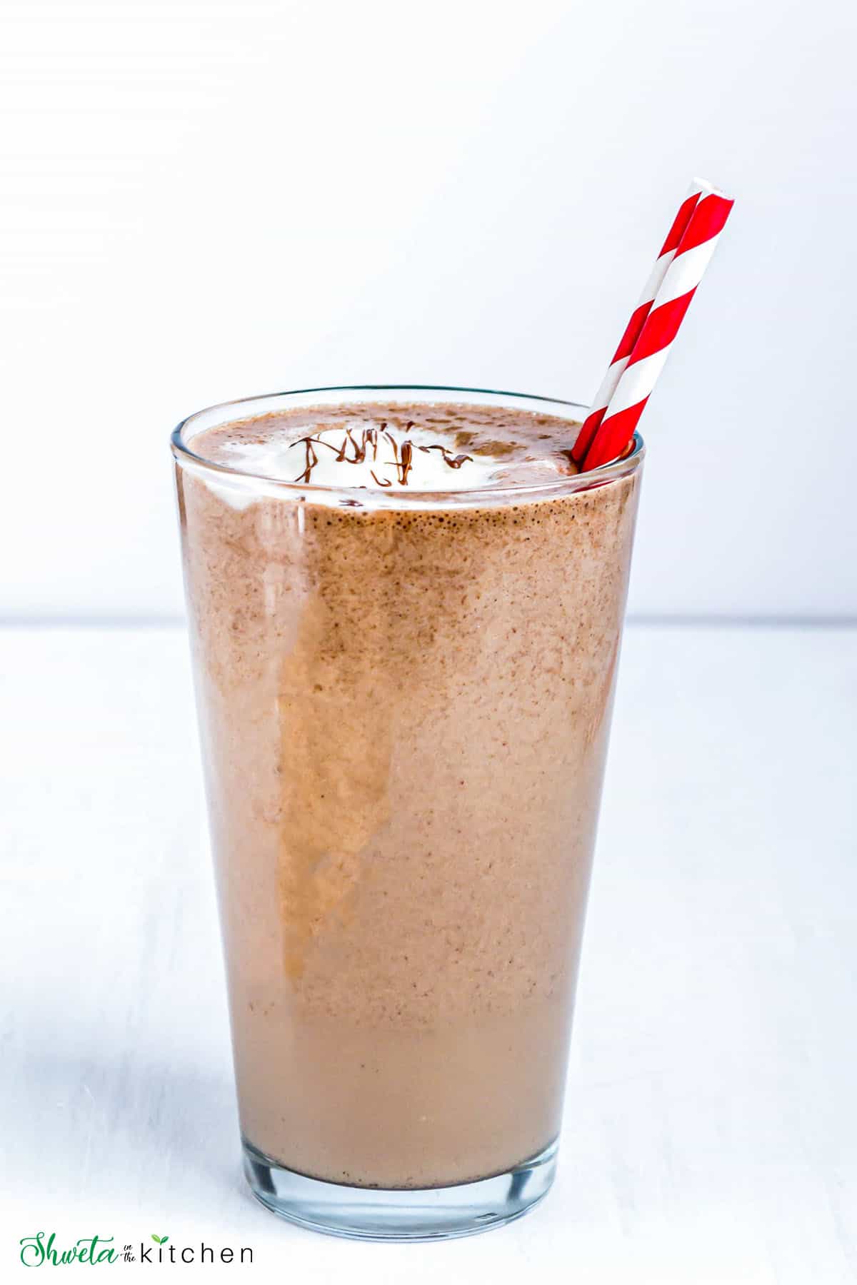 Nutella Milkshake in a glass with red striped straw