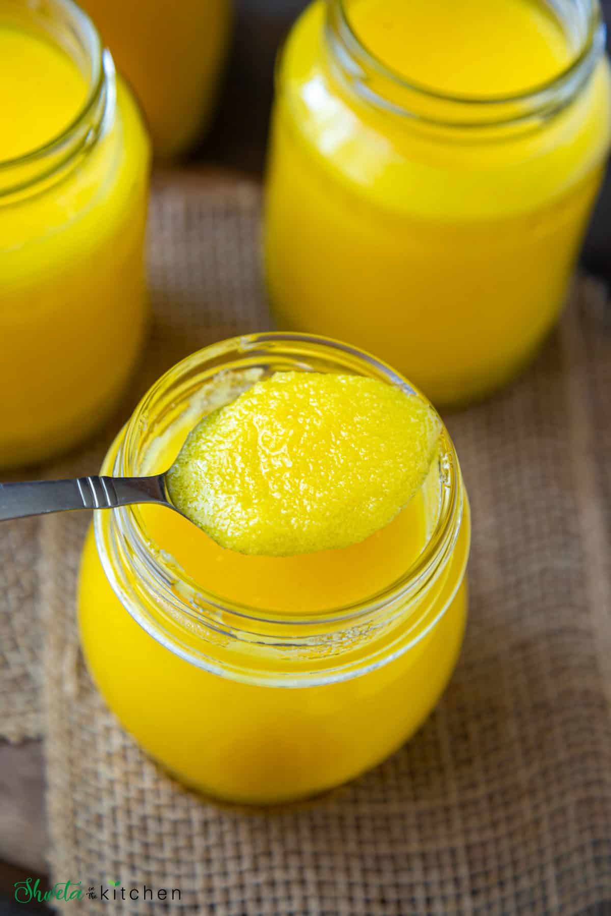 Spoonful of homemade ghee scooped out of jar