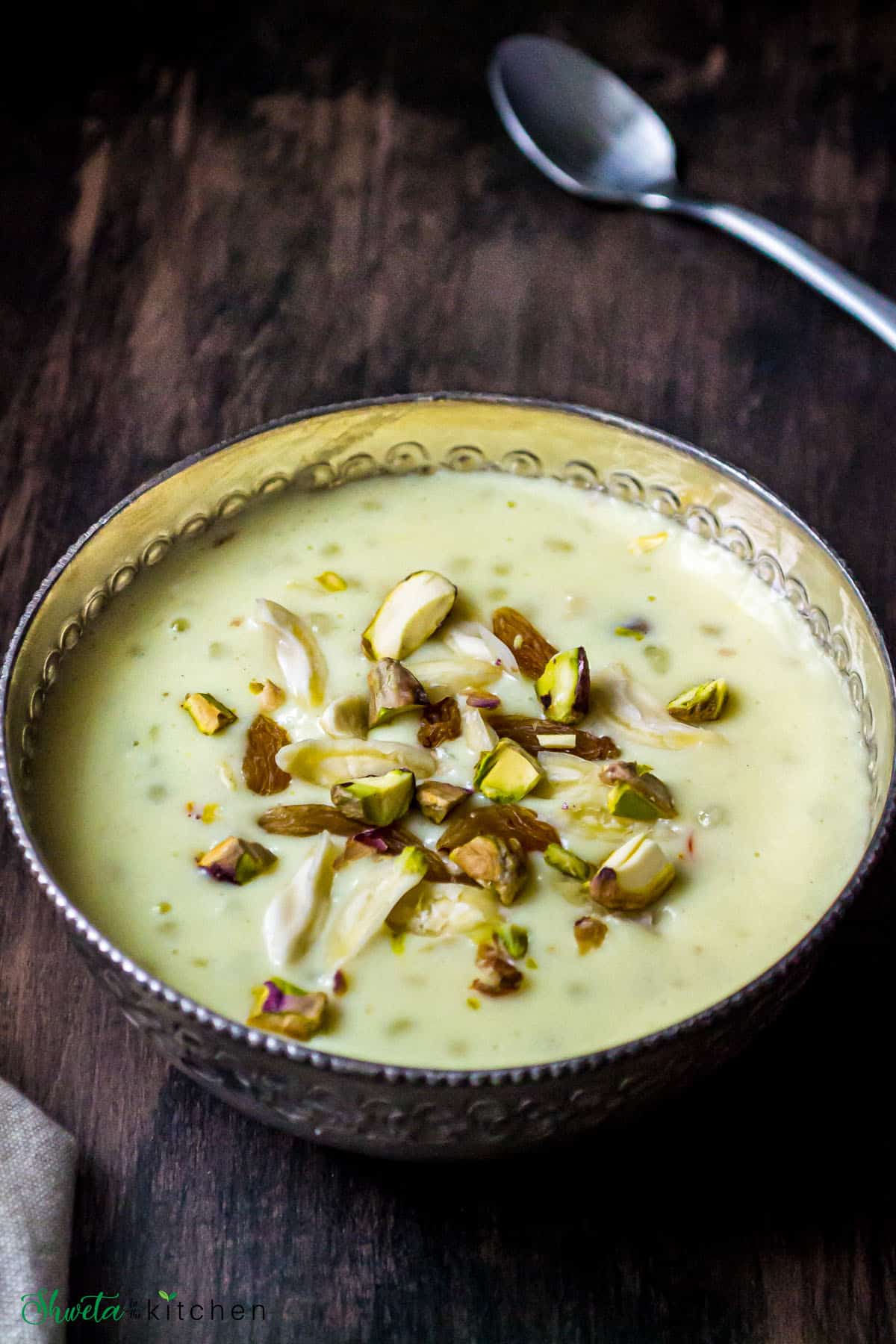 Sabudana kheer served in a silver bowl and topped with chopped nuts