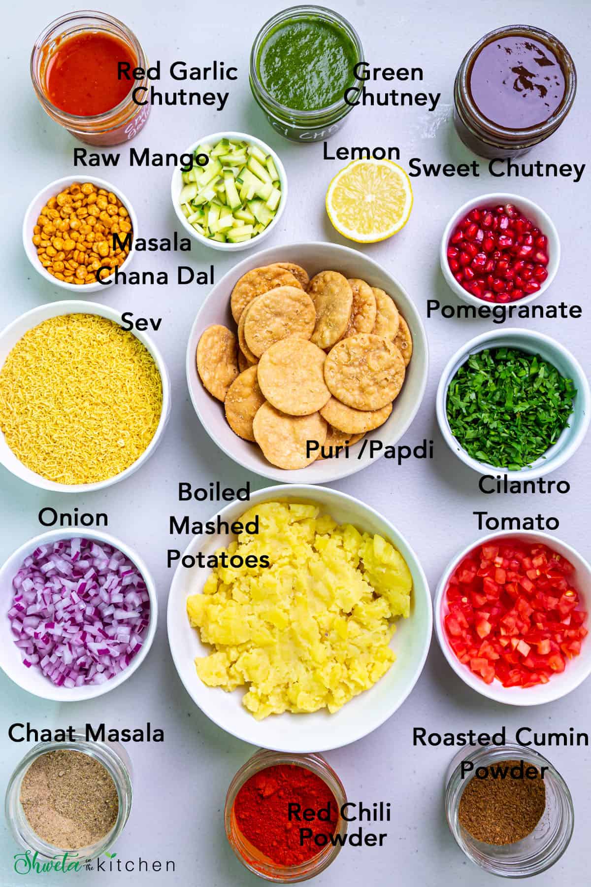 Sev puri ingredients in bowls on white surface