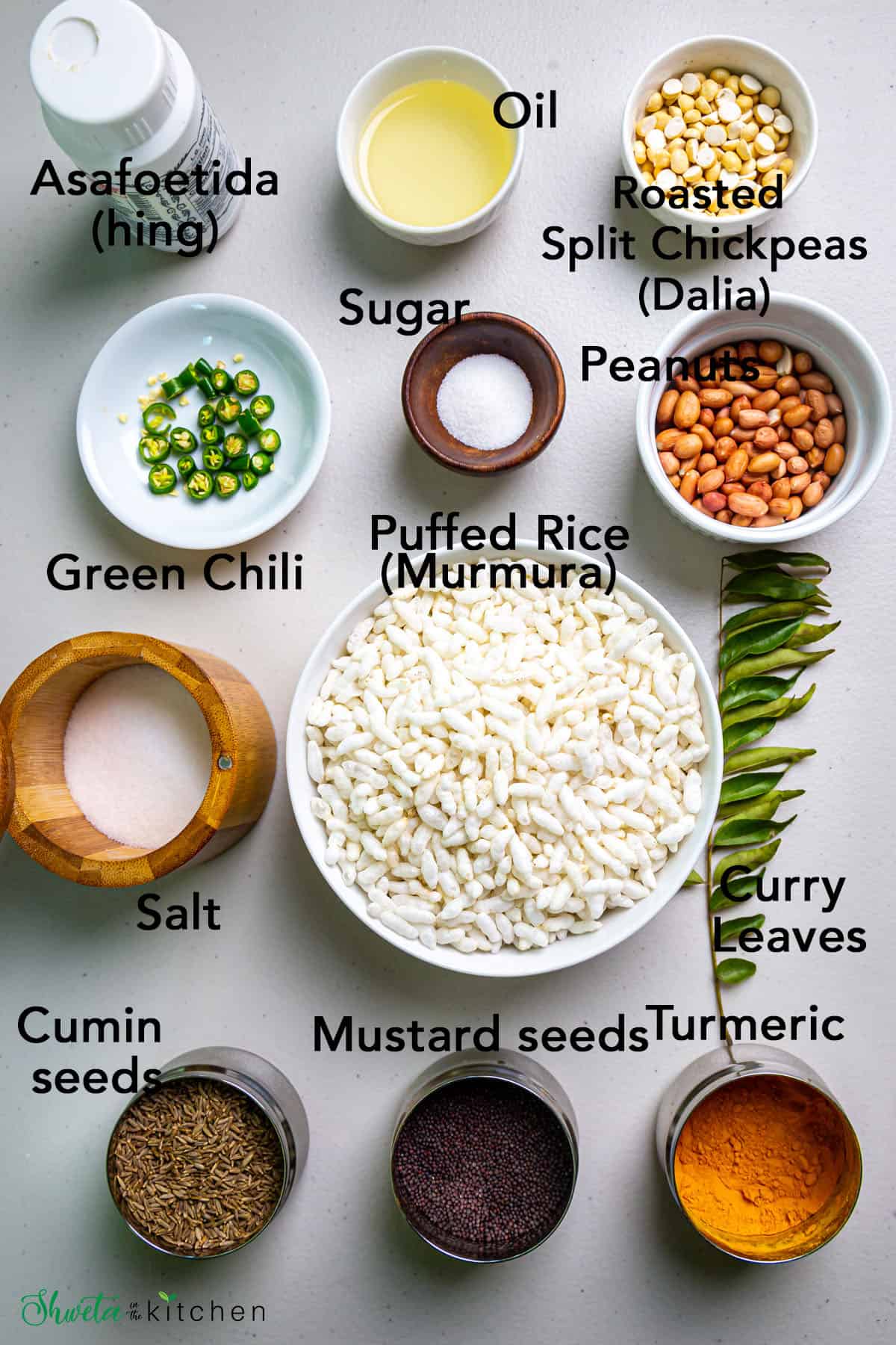 Ingredients for Murmura chivda (spicy puffed rice) in bowls on white surface