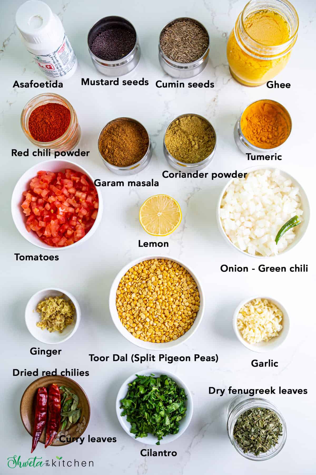 Ingredients for dal fry in bowls on white surface