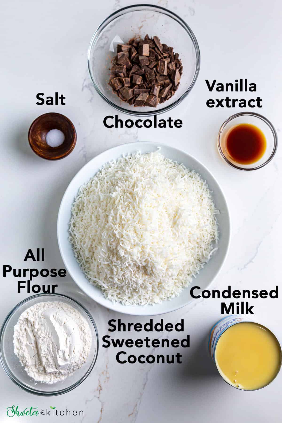 Ingredients for eggless coconut macaroons in bowls on white surface
