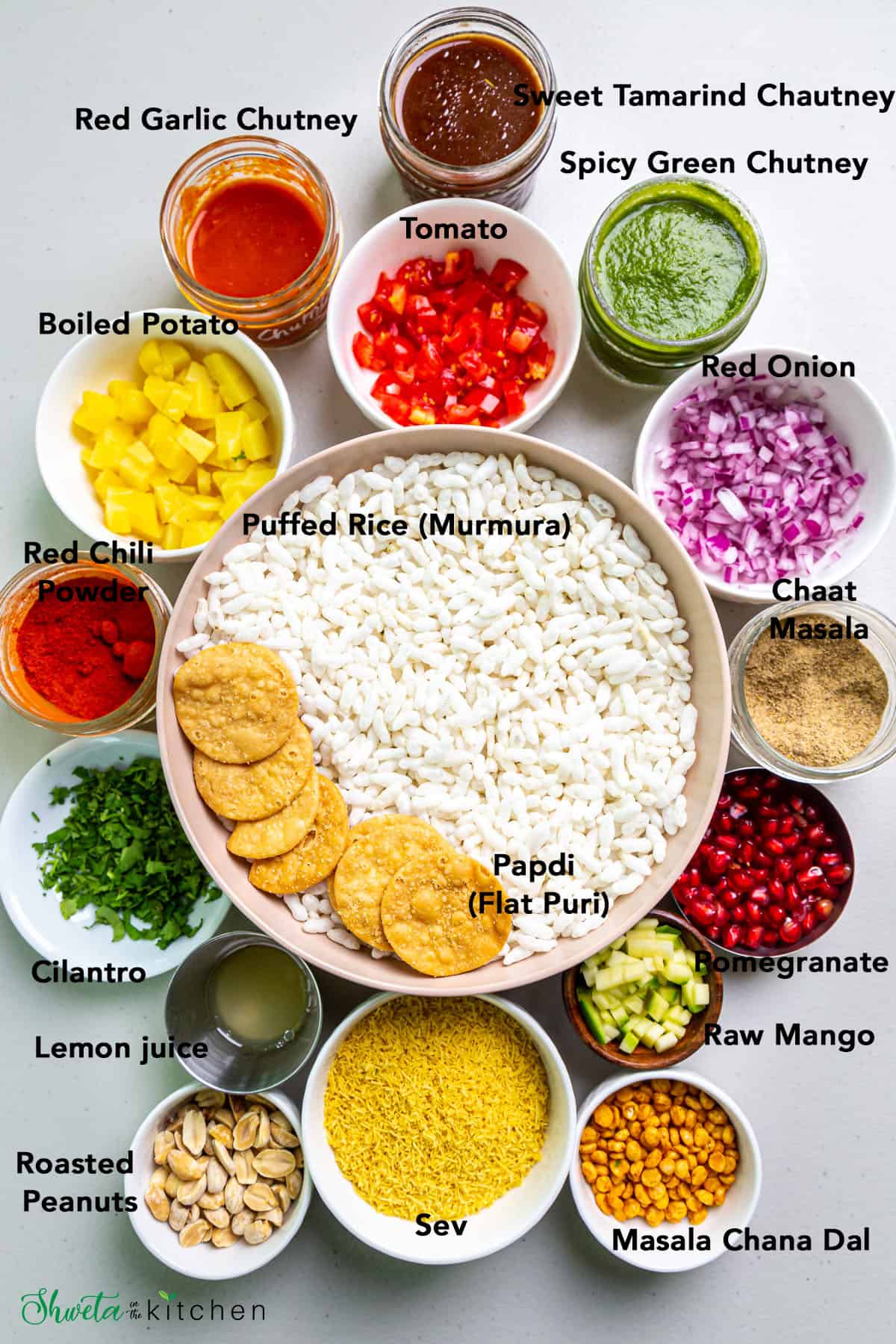 Ingredients for bhel puri arranged in bowls on white surface