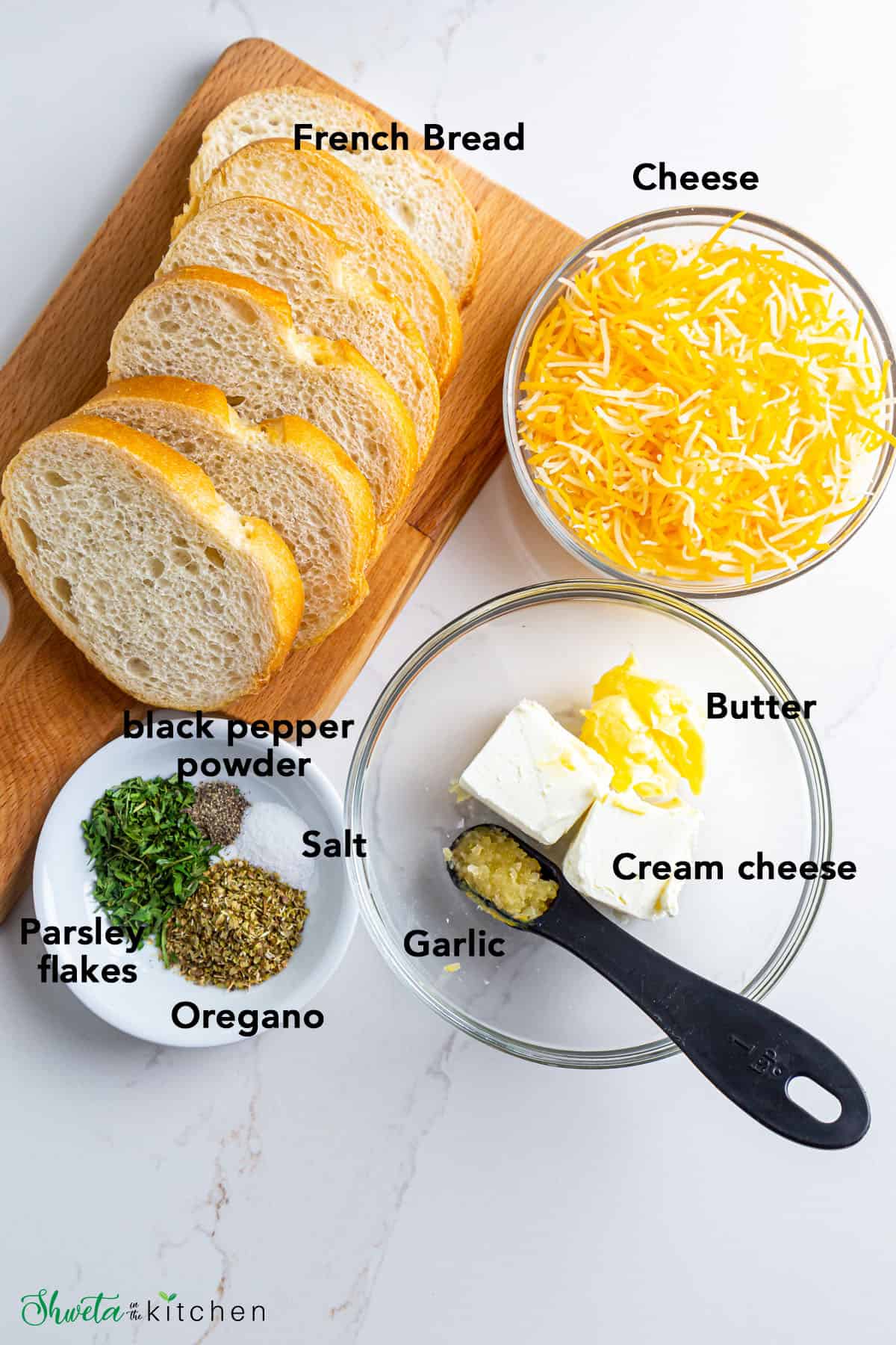 Ingredients for Air-fryer Garlic Bread laid out on white surface
