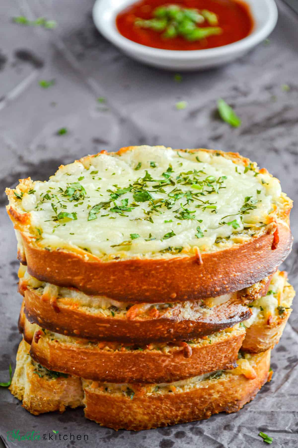 Four slices of garlic bread stacked on top of each other.