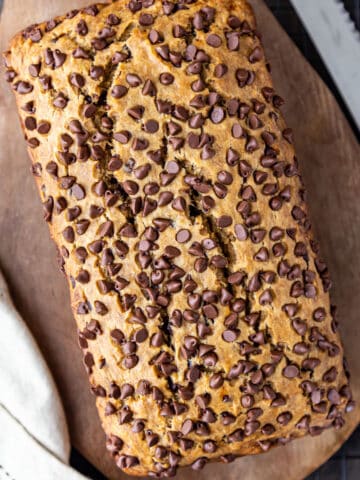 Eggless banana bread loaf with chocolate chips placed on wooden tray