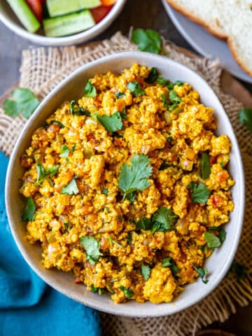 Paneer bhurji served in a bowl and garnished with cilantro