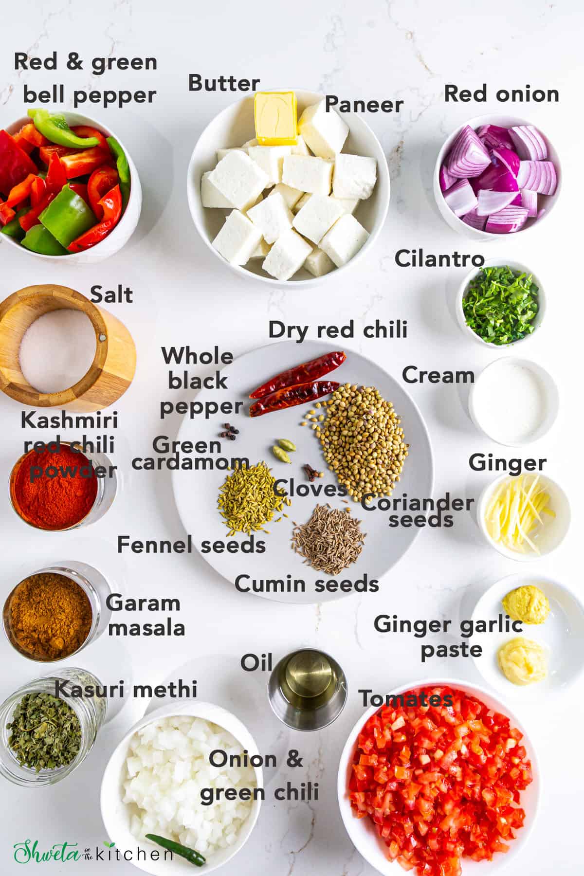 Ingredients for kadai paneer recipe arranged in bowls on white surface