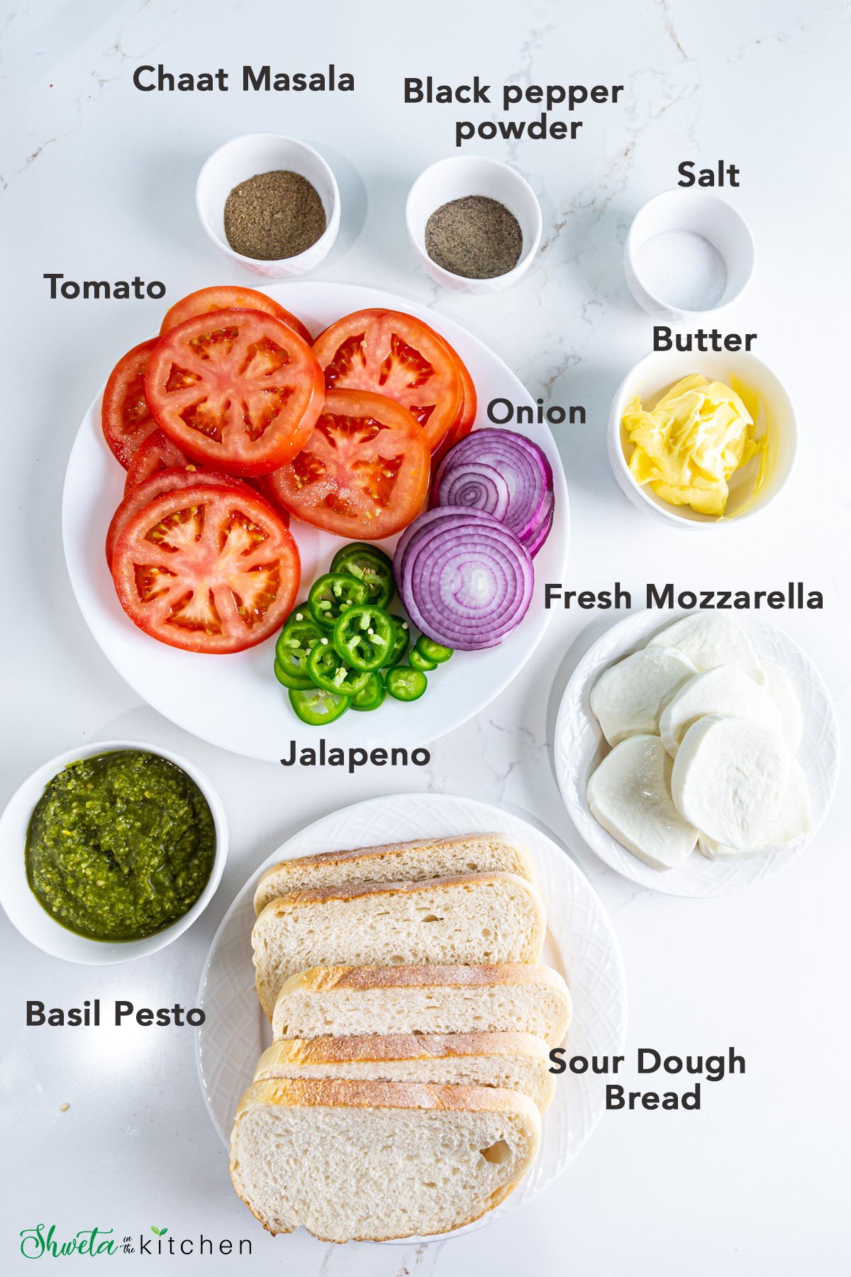 Ingredients for Tomato mozzarella sandwich placed on white surface
