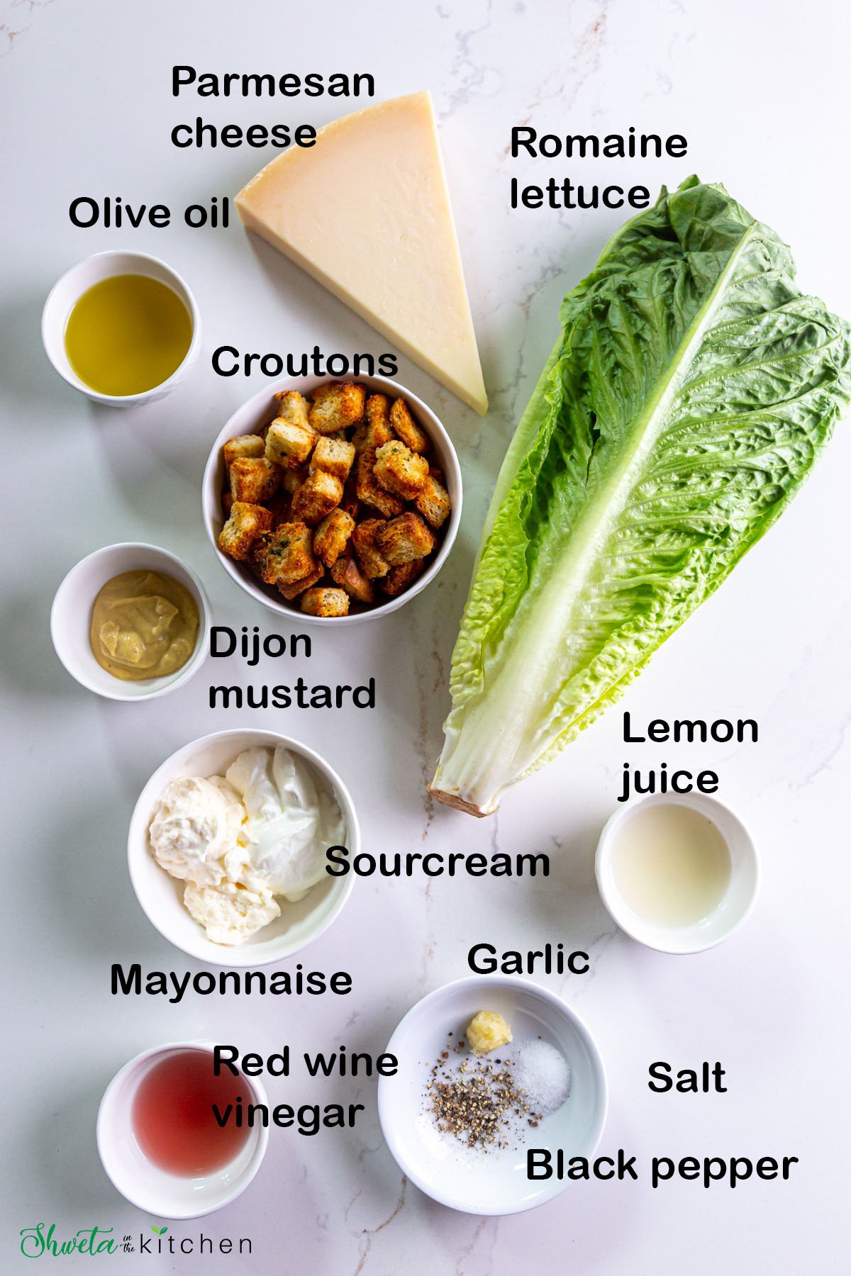 Ingredients for Vegetarian Caesar salad arranged in bowls on white surface