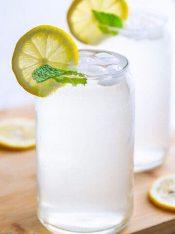 Glass of fresh squeezed lemonade garnished with lemon slice and mint leaves