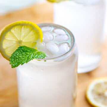 Two glass full of fresh squeezed lemonade garnished with lemon slice and mint leaves