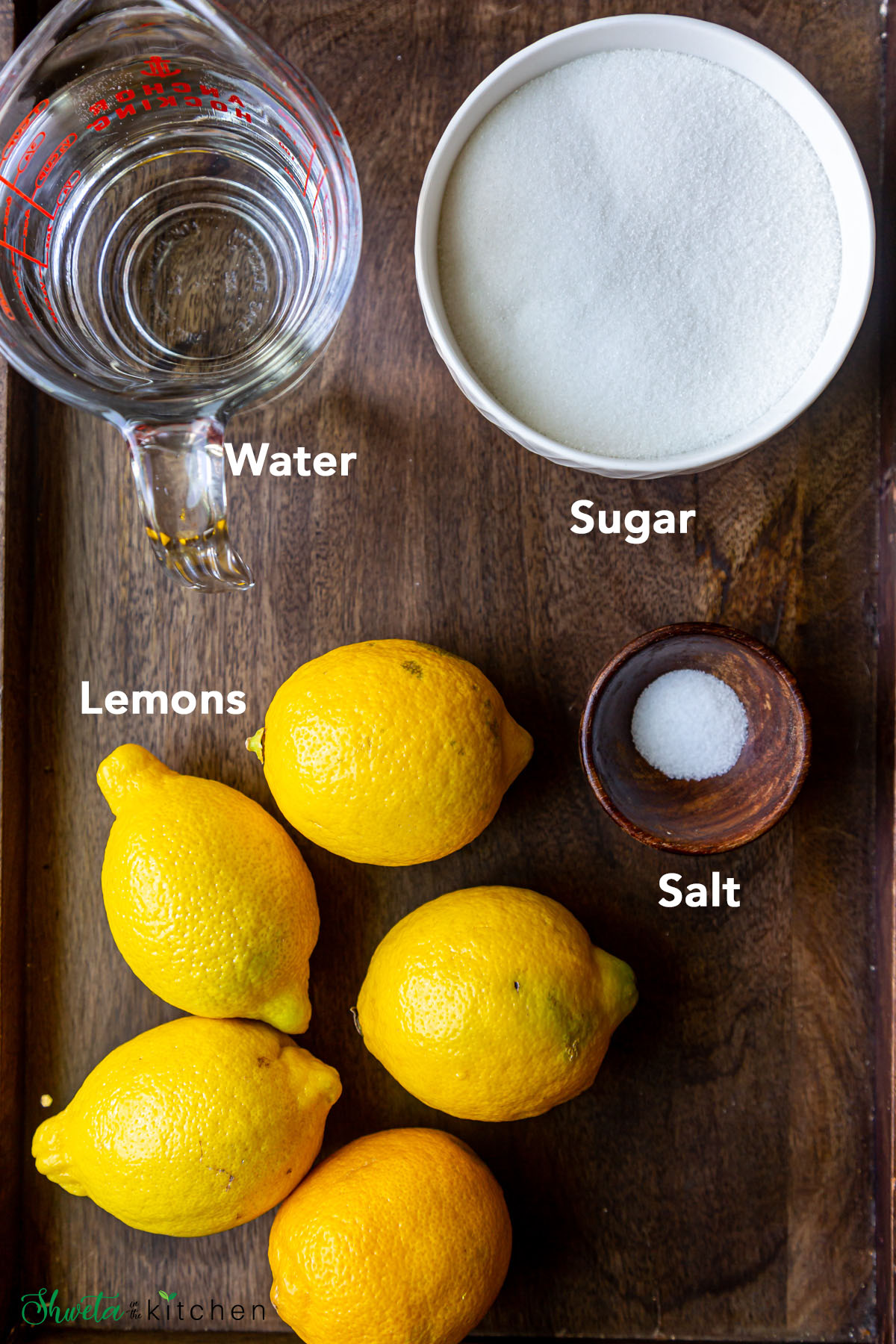 Ingredients for fresh squeezed lemonade arranged on wooden surface