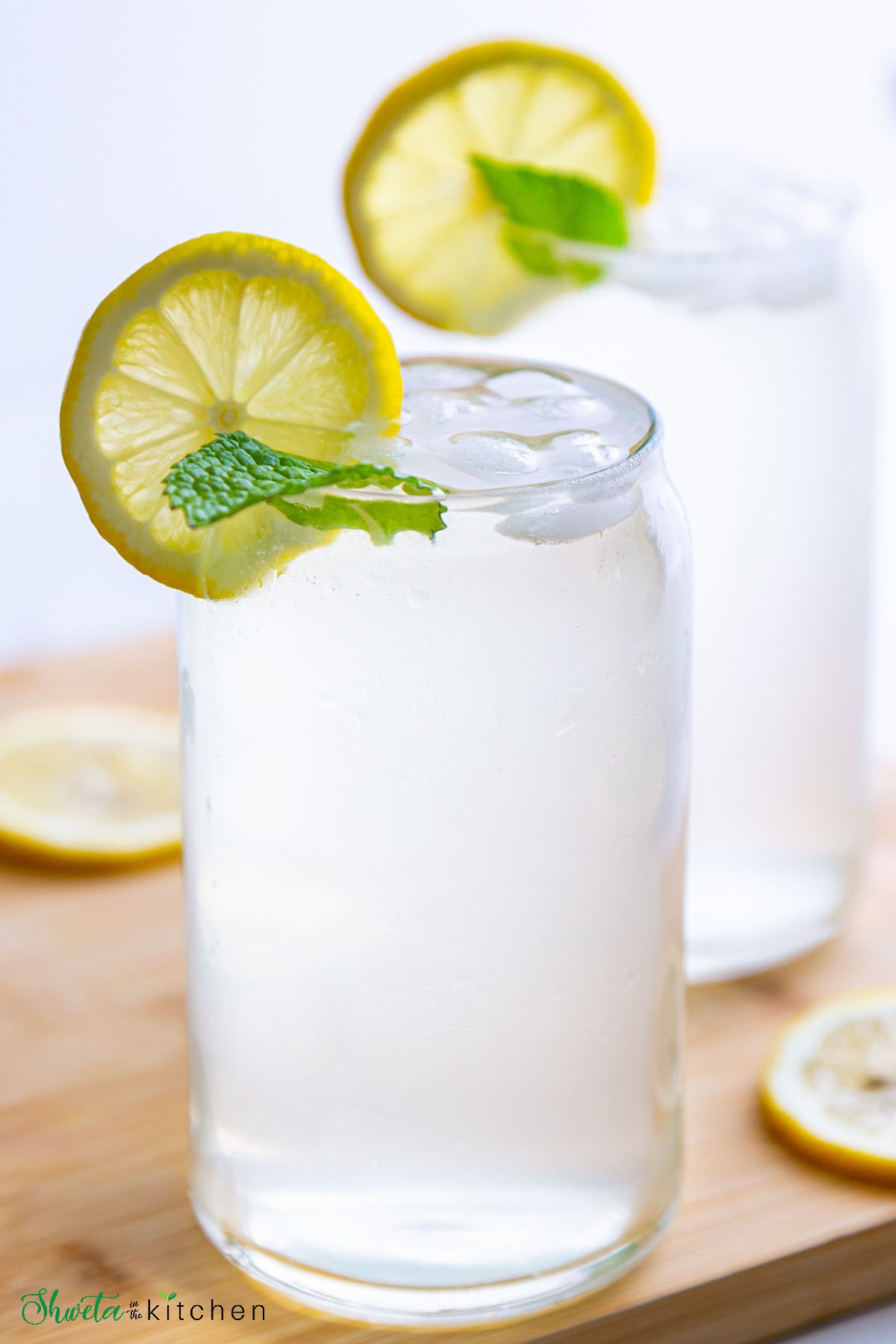 Glass of fresh squeezed lemonade garnished with lemon slice and mint leaves