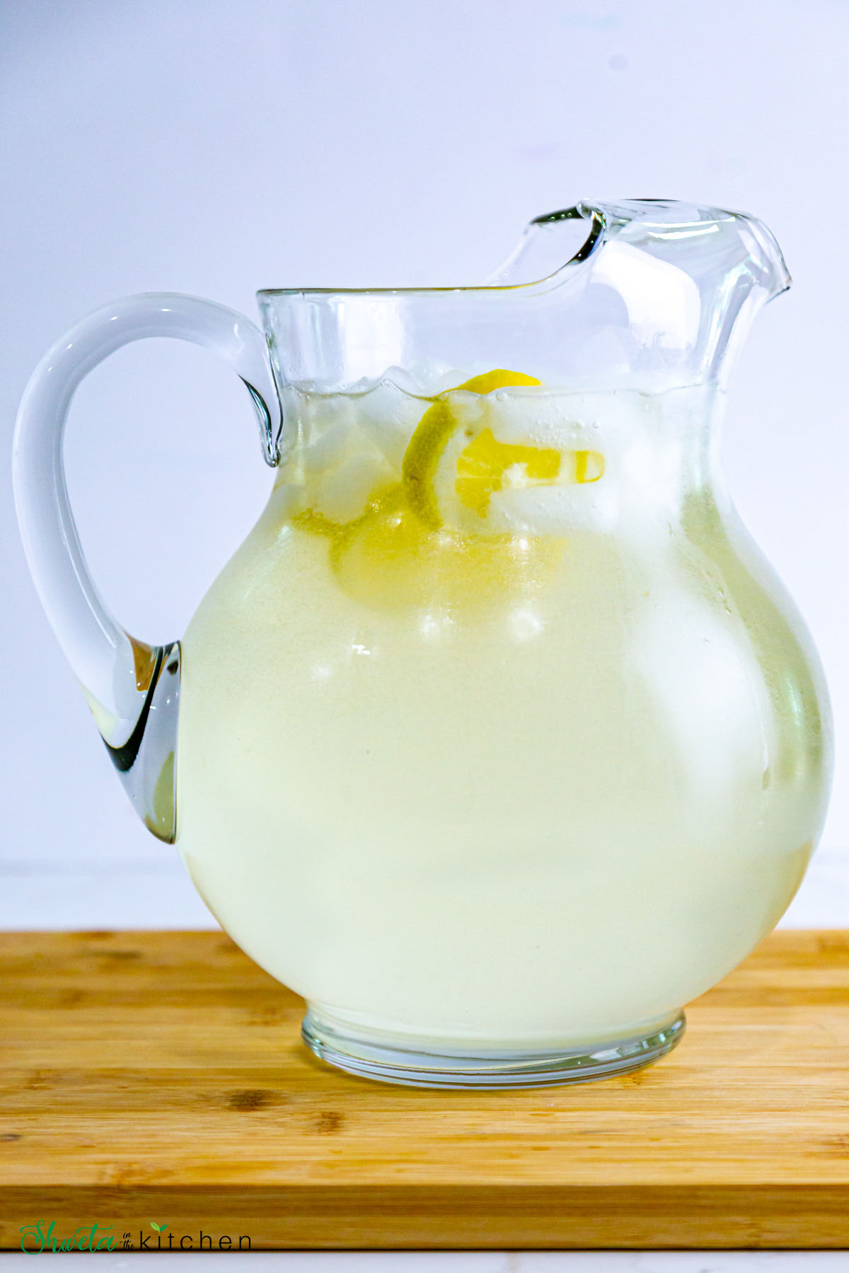 Pitcher of fresh squeezed lemonade with ice and lemon slices
