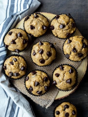 9 Banana Chocolate Chip Muffins arranged on a wooden board