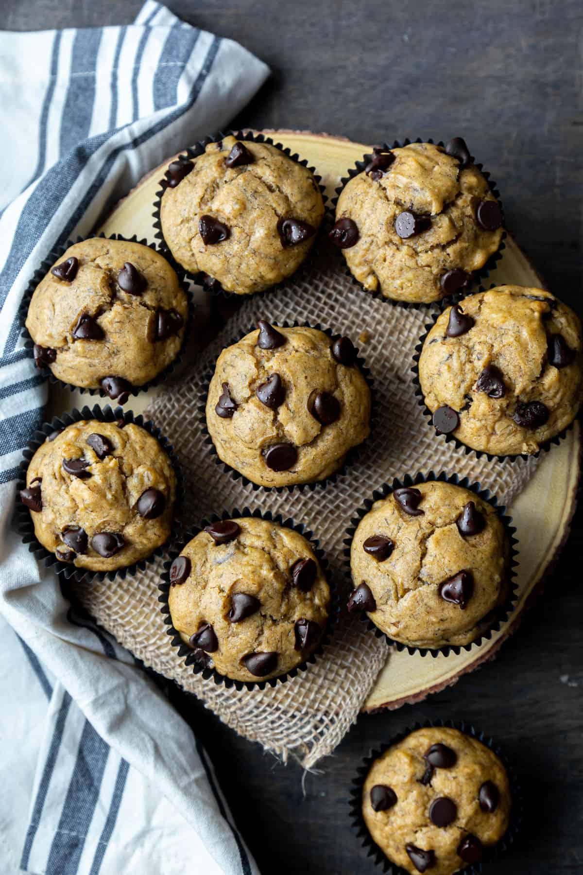 9 Banana Chocolate Chip Muffins arranged on a wooden board