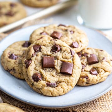 Close up view of eggless chocolate chip cookie piled on plate with other cookies
