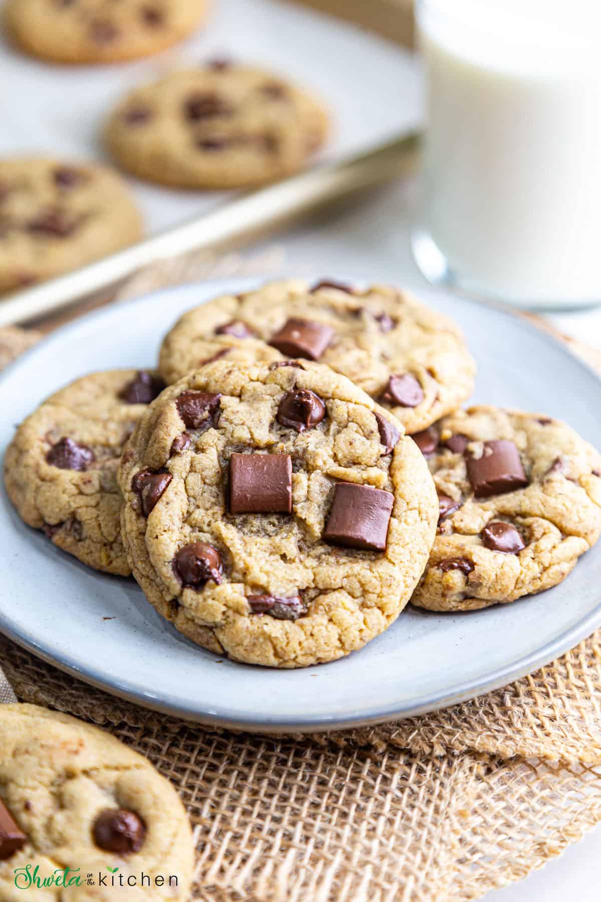 Close up view of eggless chocolate chip cookie piled on plate with other cookies