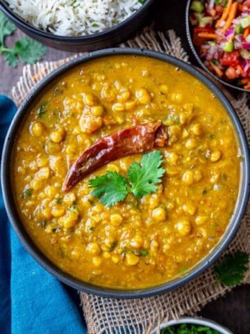 Chana dal served in a black bowl and garnished with fresh cilantro