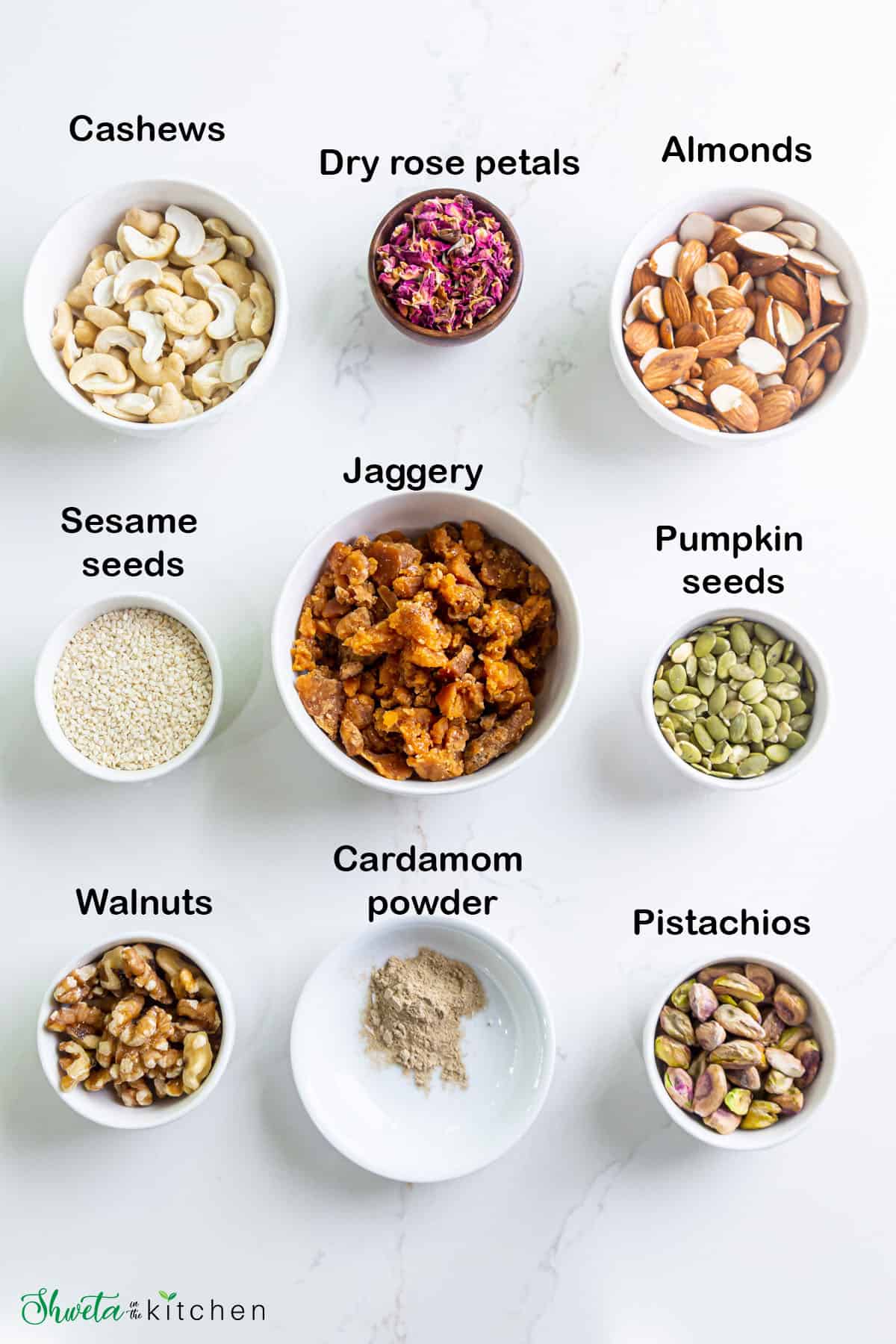 Dry fruit chikki ingredients in bowls on white surface