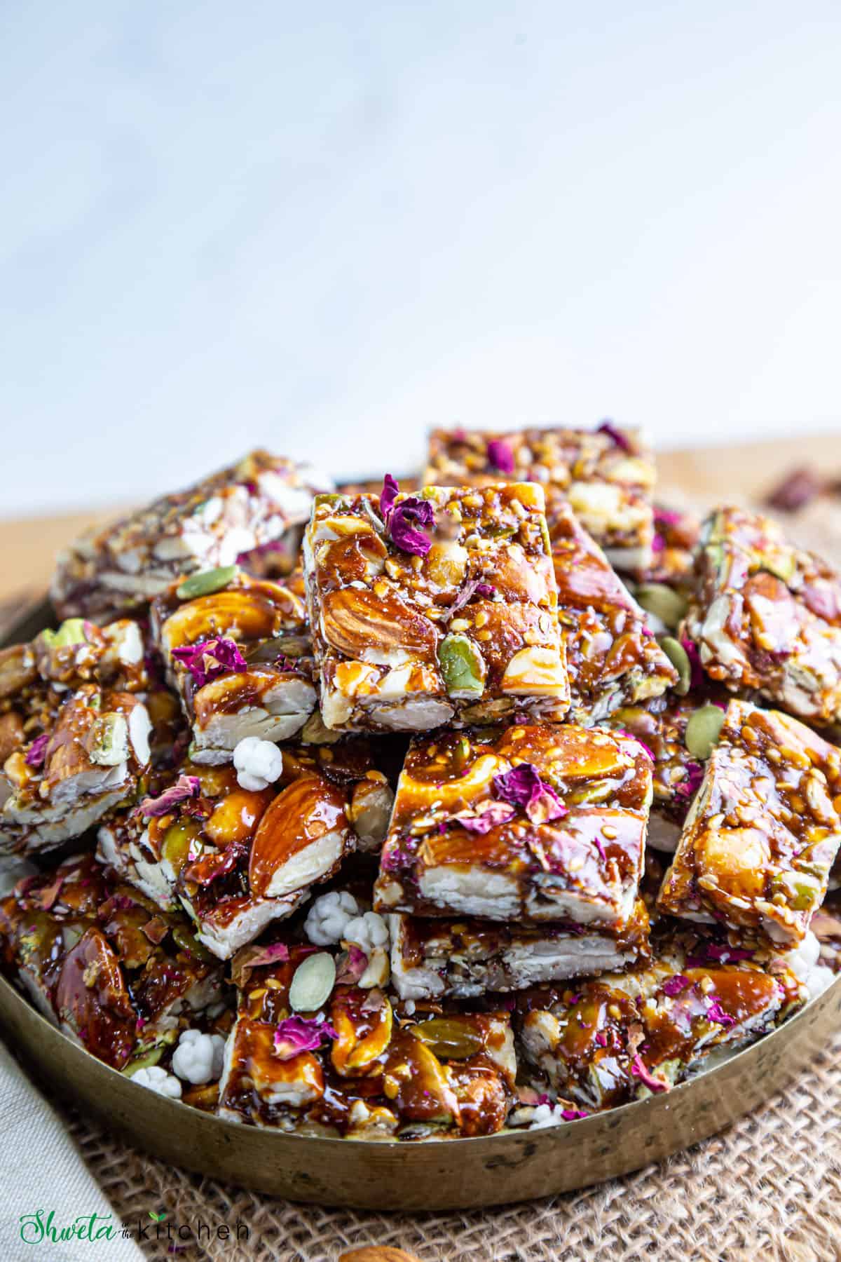 Side view of dry fruit chikki stacked up on plate