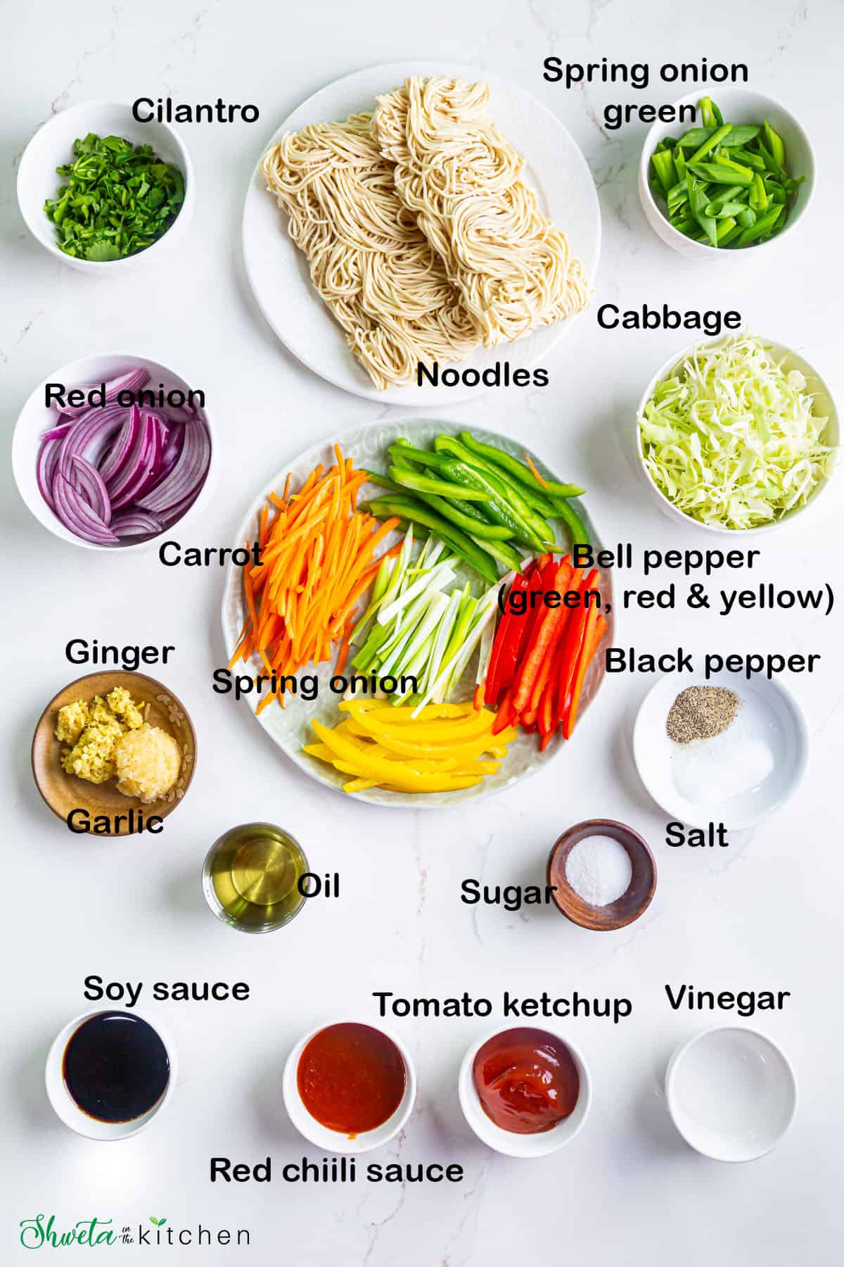 Ingredients for veg noodles placed in bowls on white surface