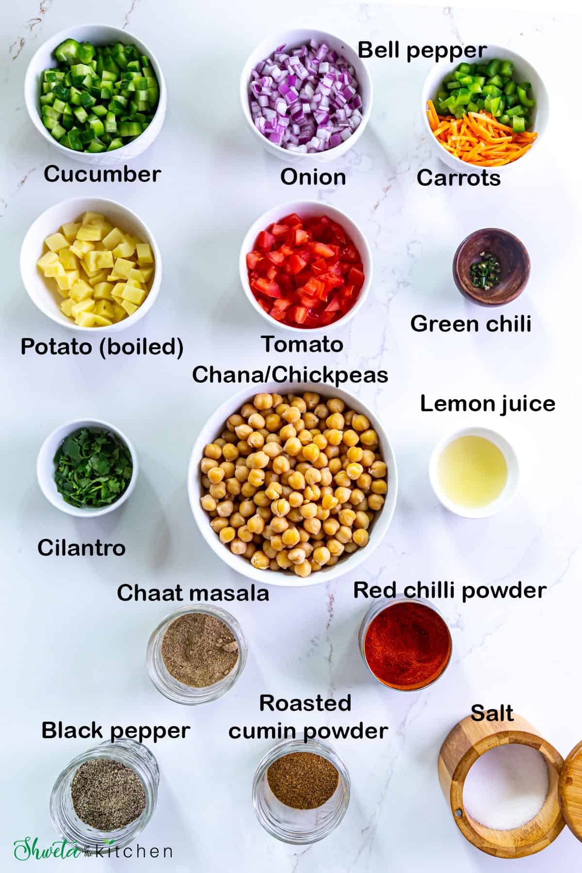 Ingredients for chana salad placed in bowls on white surface