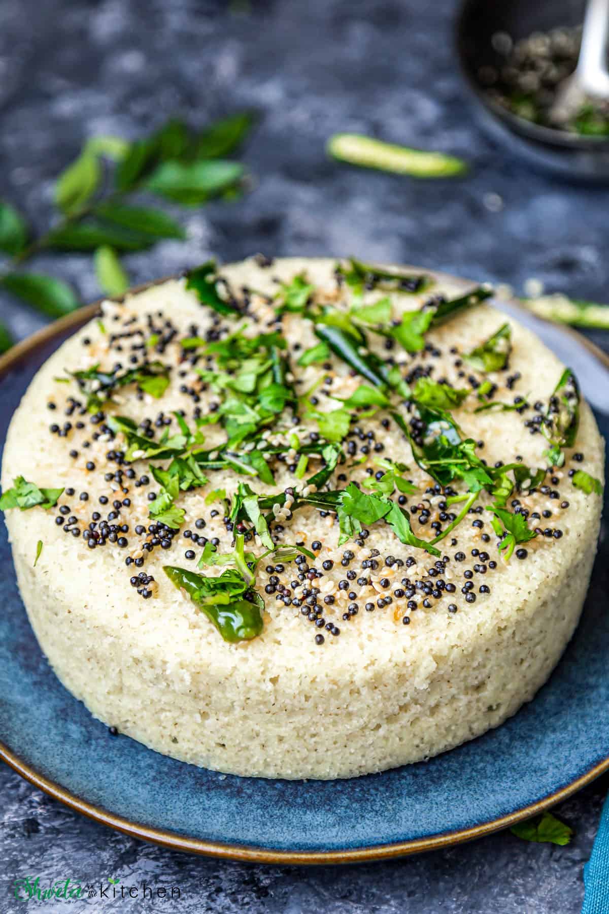 Round Rava dhokla with tempering placed on blue plate