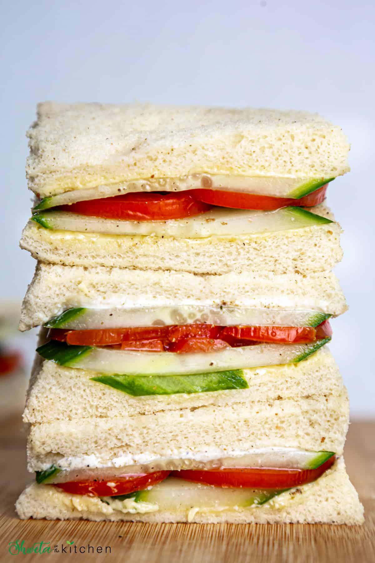 Vertical stack of tomato cucumber sandwiches placed on top of each other