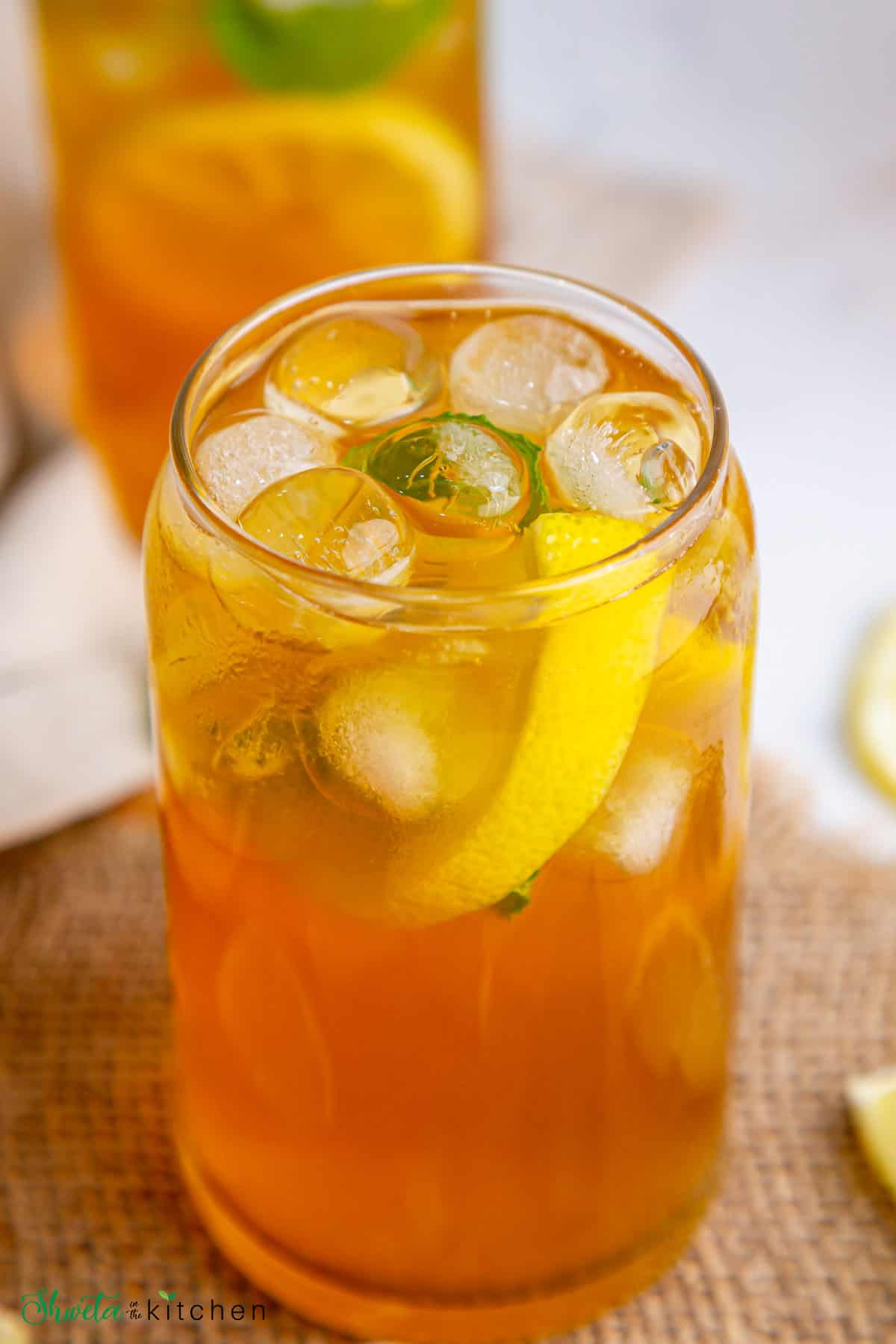 Refreshing lemon iced tea served in a tall glass with ice cubes and lemon slices