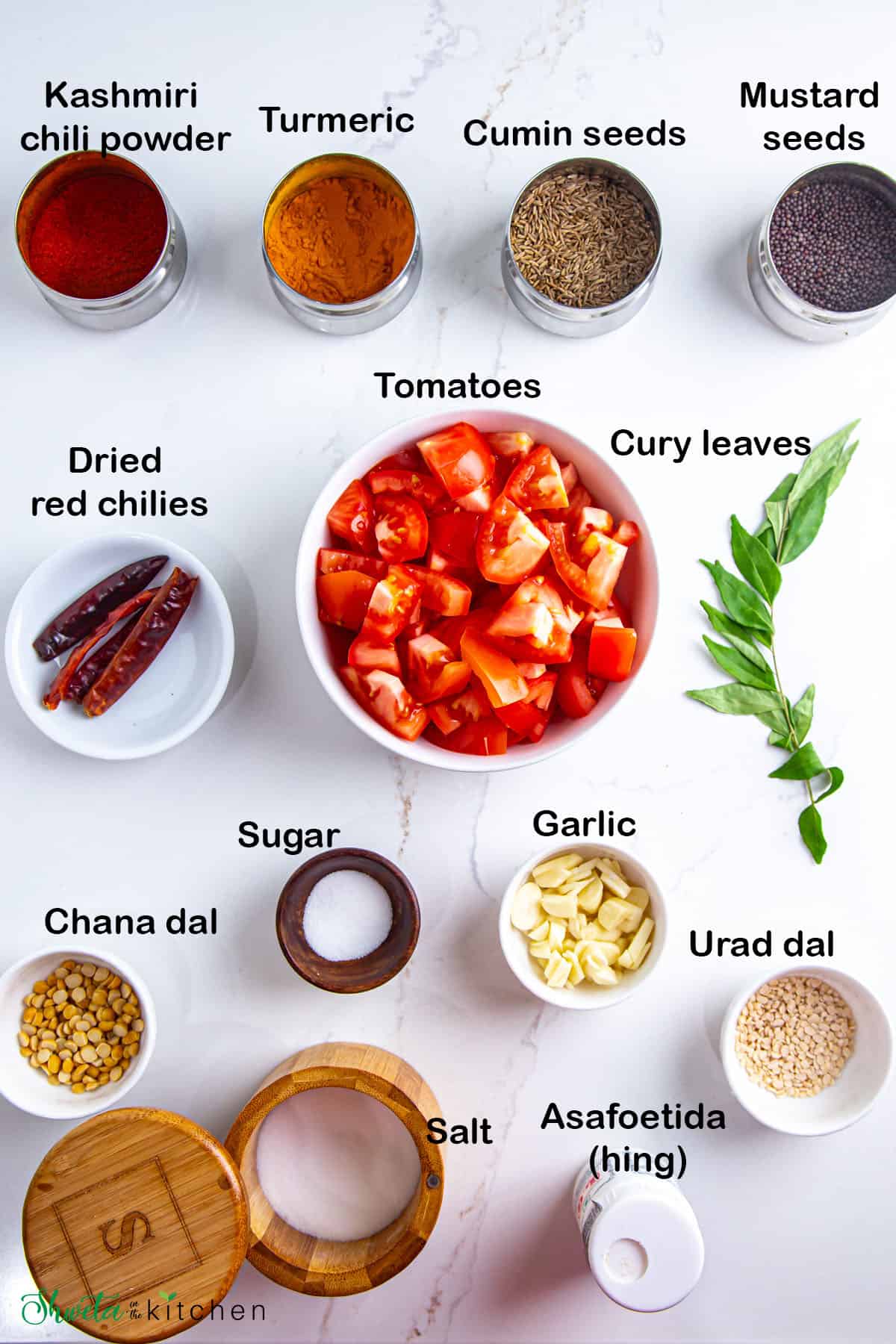 Top view of tomato chutney ingredients placed in bowls on white surface