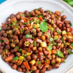 Top view of a bowl full of kala chana chaat (black chickpea salad)
