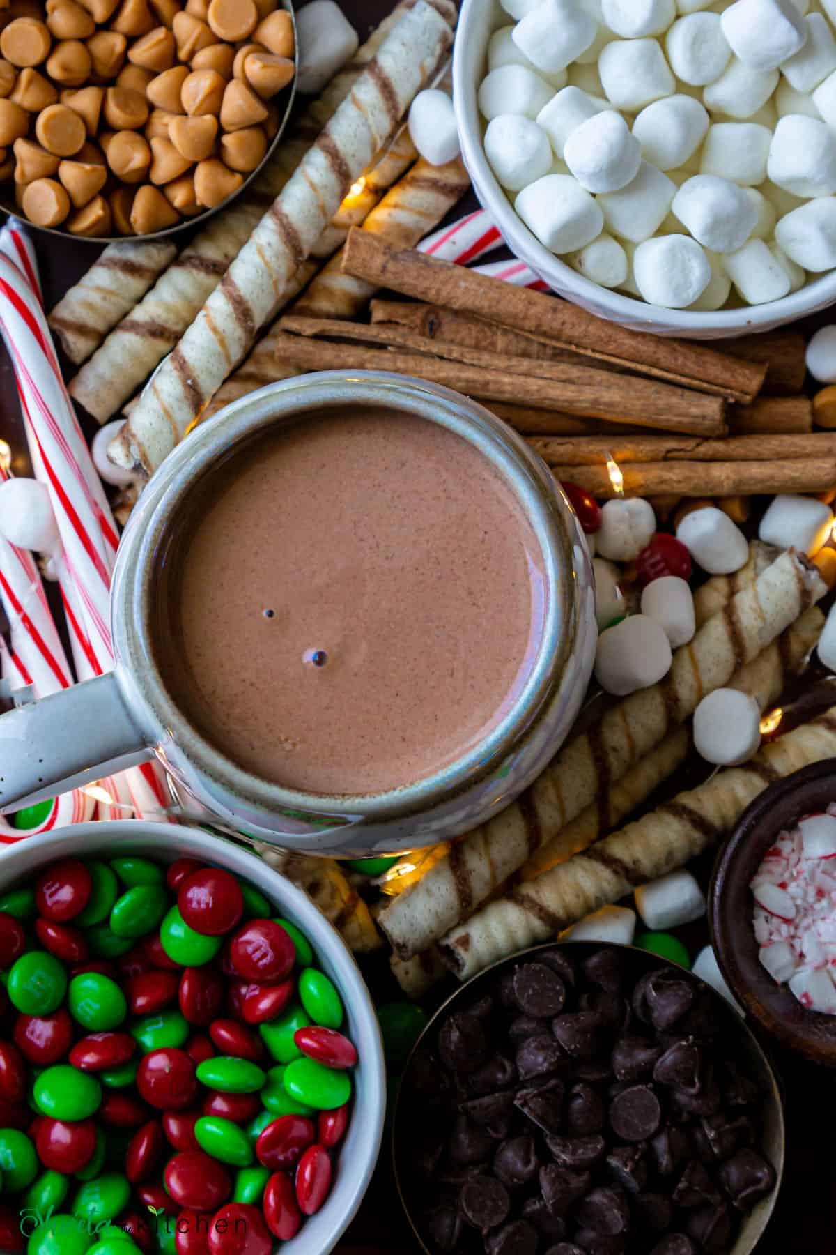Hot chocolate bar set up with in a mug full of hot chocolate surrounded with all toppings.